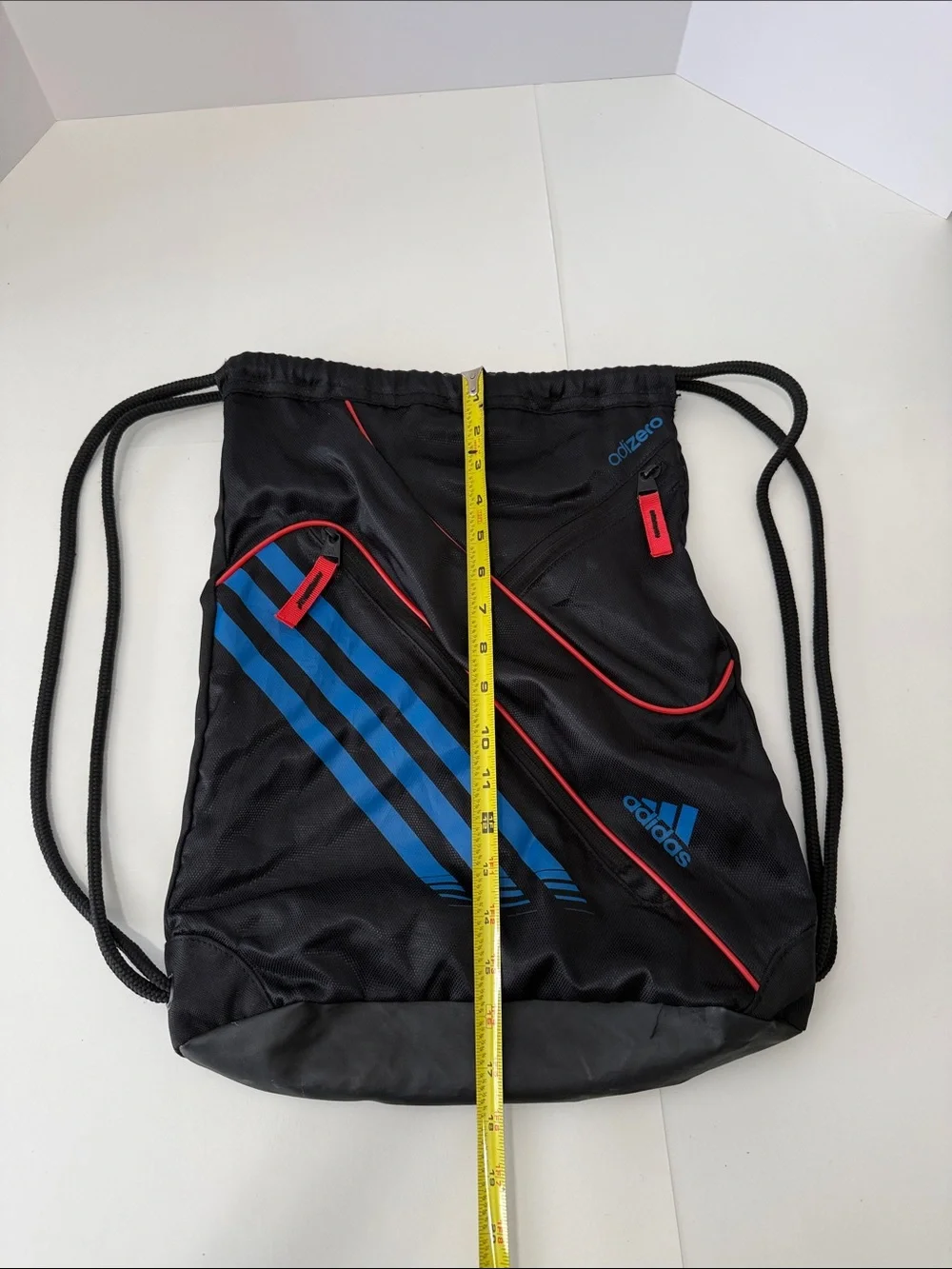 adidas Black Drawstring Backpack with Blue Stripes and Red Accents